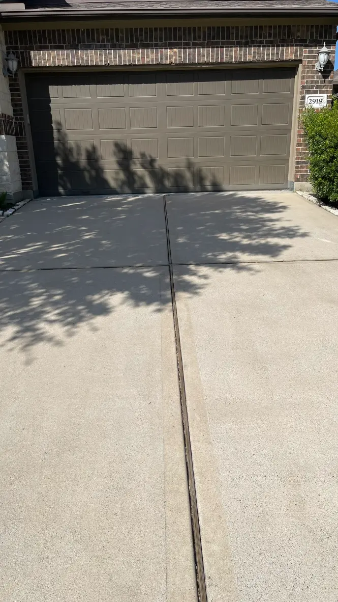 Concrete driveway expansion joint with metal control strip – Garage entrance installation and maintenance Houston Texas