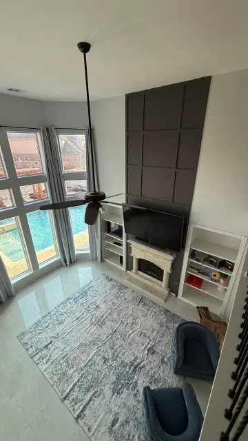 Overhead view of family room with fireplace, ceiling fan, and pool access – Engineered flooring installation Houston Texas