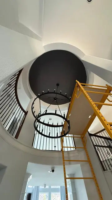 Stunning circular staircase with black railing and dome ceiling during remodel – Luxury interior details Houston TX